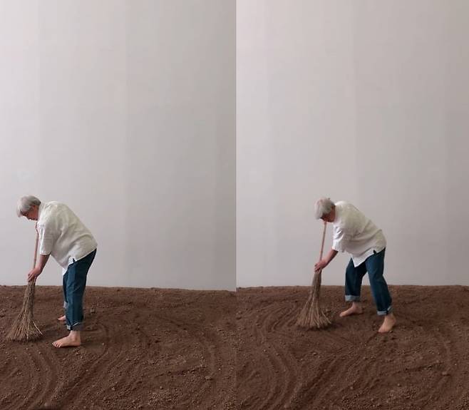 고향 청도에서 가져온 흙을 빗자루로 쓸며 전시의 서막을 연 이배 작가. /강은영