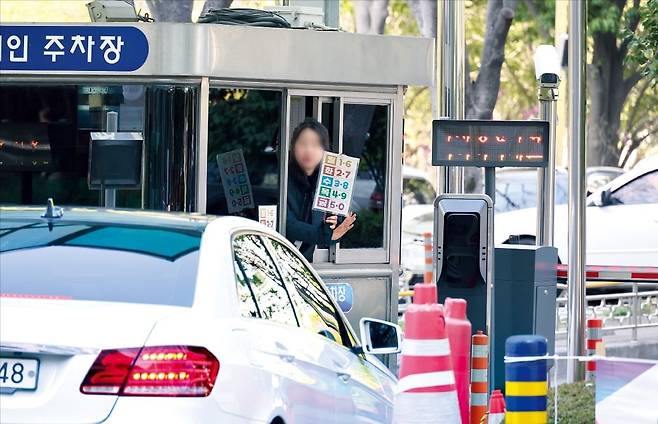 < “수요일엔 끝자리 3·8 주차 안돼요” > 8일 부산 연산동 부산시청 민원인 전용 주차장에서 직원이 번호판 끝자리 3·8에 해당하는 차량 출입을 막고 있다. 이날부터 공공기관이 운영하는 공영주차장에는 승용차 5부제(요일제)가 시행됐다. /연합뉴스