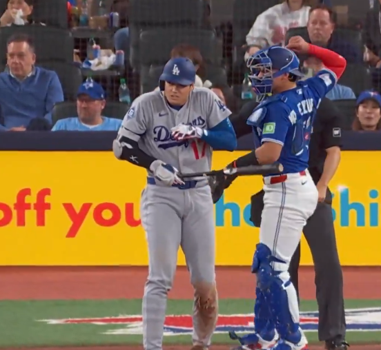 LA 다저스 오타니가 8일 토론토전에서 5회초 타석에서 상대 포수 발렌수엘라의 1루  송구때 왼팔을 맞아 깜짝 놀라고 있다. 중계 화면 캡처