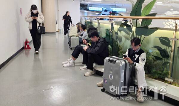 9일 제주공항 항공편이 대거 결항되면서, 표를 구하지 못한 승객들이 공항 바닥 등에 앉아 대기하고 있다. ⓒ헤드라인제주