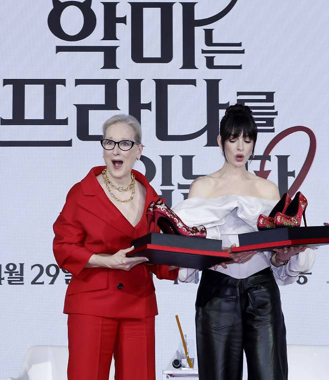 배우 메릴 스트립(왼쪽), 앤 해서웨이가 8일 서울 종로구 포시즌스 호텔에서 열린 영화 ‘악마는 프라다를 입는다2’ 내한 기자간담회에서 관계자에게 꽃신 선물을 받은 뒤 깜짝 놀라고 있다.(사진=뉴시스)
