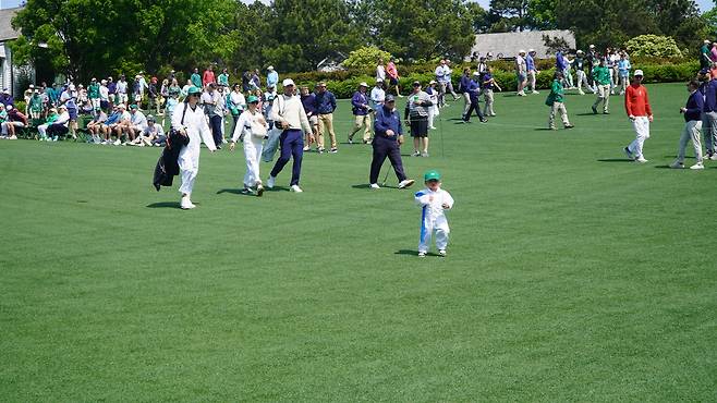 스코티 셰플러의 장남 베넷(맨 앞)이 8일(현지 시간) 미국 조지아주 오거스타 내셔널GC 옆 코스에서 열린 마스터스 파3 콘테스트 중 부모에 앞서 서둘러 그린 쪽으로 이동하고 있다. 오거스타=양준호 기자