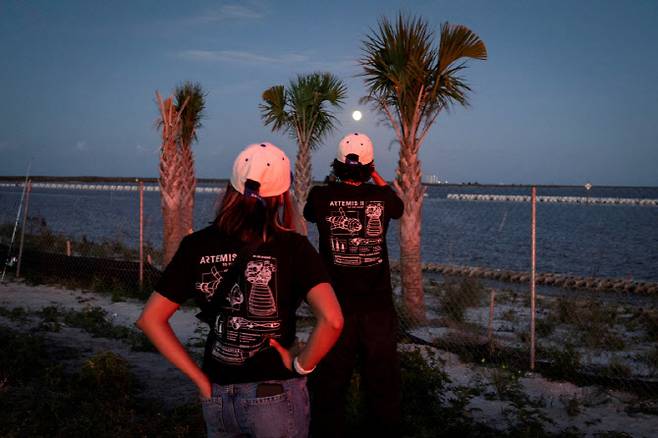 지난 1일(현지시간) 미국 플로리다주 타이터스빌에서 한 남성이 NASA의 아르테미스 II(2호) 달 비행 임무에 투입된 차세대 달 탐사 로켓 '스페이스 론치 시스템(SLS)'과 오리온 유인 캡슐이 케네디 우주센터에서 발사된 뒤 달을 배경으로 휴대전화로 사진을 찍고 있다. (사진=로이터)