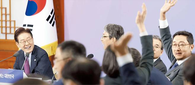 李 국민경제자문회의 주재… “저요!” 발언권 경쟁  9일 청와대에서 국민경제자문회의를 주재한 이재명 대통령이 발언권을 얻기 위해 손을 든 참석자들을 웃으며 바라보고 있다. 이 대통령은 이날 “자발적 실업은 자기가 좋아서 그만둔 거라 실업수당을 안 준다는 생각은 매우 전근대적이지 않나”라며 “수정해야 하는 부분”이라고 말했다. /연합뉴스