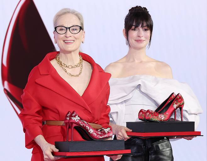 배우 메릴 스트리프(왼쪽)와 앤 해서웨이가 8일 서울 종로구 포시즌스호텔에서 열린 영화 ‘악마는 프라다를 입는다 2’ 기자간담회에서 꽃신을 재해석한 하이힐을 선물 받은 뒤 포즈를 취하고 있다.  연합뉴스