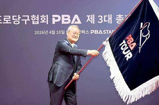 PBA 3대 총재로 취임한 윤영달 신임총재가 협회기를 들어올리고 있다. (사진=PBA)