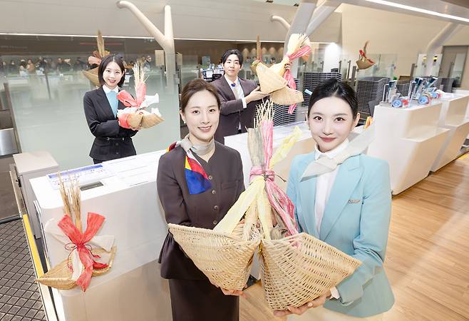 대한항공과 아시아나항공 직원들이 인천공항 제2여객터미널 탑승 수속 카운터에서 기념사진을 촬영하고 있다. [대한항공 제공]