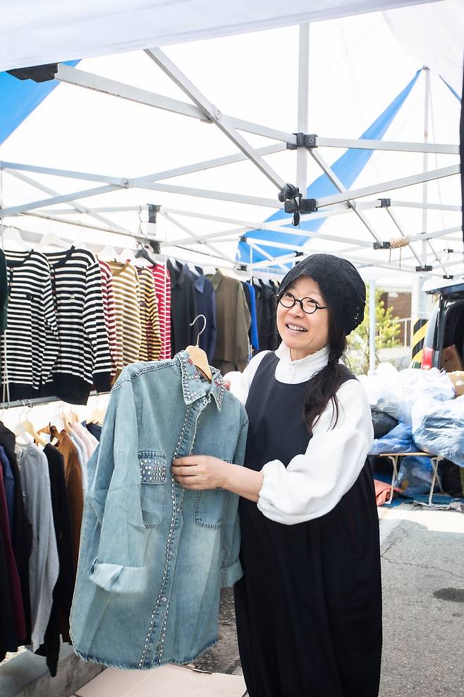 괴산전통시장을 오가던 길에 "단골 식당인 '사나이짬뽕' 집 아들이 입으면 잘 어울리겠다"며 노점에서 옷을 사고 있는 이효재. "서울 오가는 길에 이곳 이웃들에게 도시에서나 살 수 있는 선물을 사서 건네곤 하는데, 그럴 때면 파김치 같은 반찬이나 농작물로 되돌려 받곤 해요. 재미있는 곳이죠?" / 김종연 영상미디어 객원기자