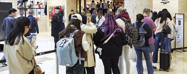 < “쇼핑하러 한국 백화점 왔어요” > 10일 서울 시내 한 백화점 안내데스크 앞에 외국인 관광객이 줄을 서 있다. 올해 외국인 관광객은 처음으로 2000만 명을 넘어 역대 최대를 기록할 전망이다. /임형택 기자