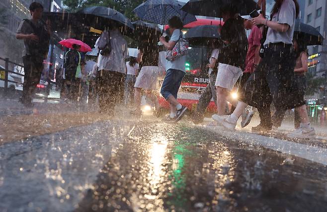 서울 강남역 인근에서 시민들이 우산을 쓴 채 이동하고 있다. 이날 기상청은 중부지방과 호남을 중심으로 많은 비를 예보했다.[연합]