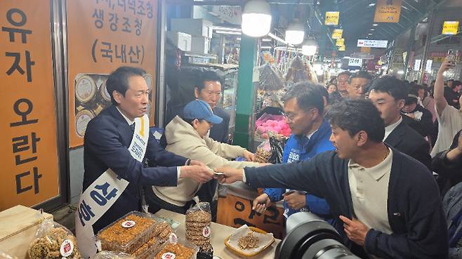 11일 오후 강릉중앙시장은 찾은 더불어민주당 우상호 강원도지사 예비후보와 정청래 대표, 김중남 강릉시장 예비후보 등이 상인들과 인사를 나누며 소통하고 있는 모습. 우상호 예비후보 캠프 측 제공