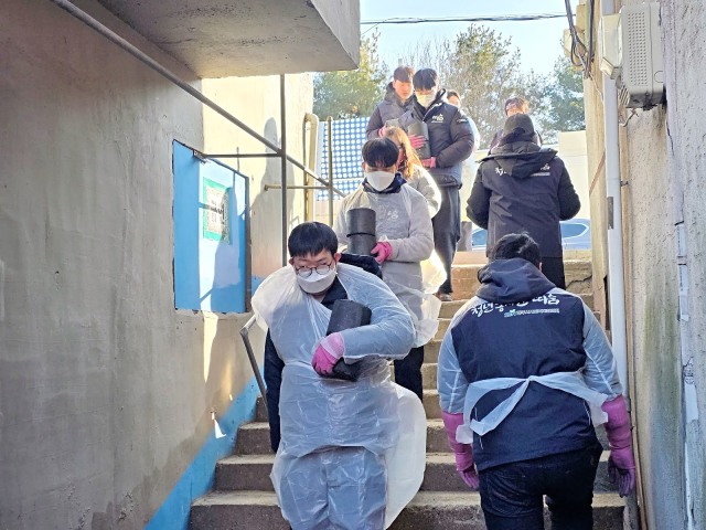 ▲한기명 씨가 동료들과 함께 연탄봉사 하는 모습ⓒ한기명