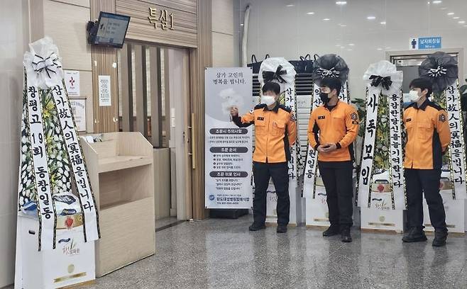 12일 전남 완도의 한 장례식장에 마련된 순직 소방관들의 빈소 입구에서 동료 대원들이 굳은 표정으로 서서 조문객들을 맞이하고 있다. 아준경 기자