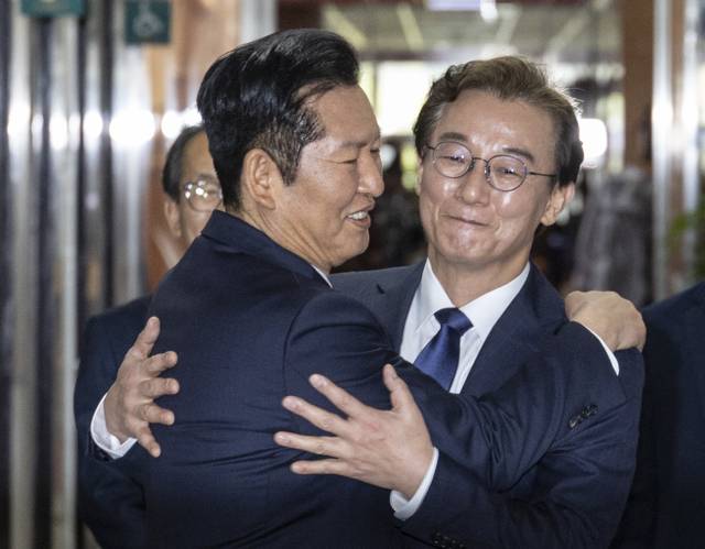 6ㆍ3 지방선거 더불어민주당 부산시장 후보로 확정된 전재수(오른쪽) 의원이 지난 4월 10일 국회 본청에서 민주당 대표실 복도로 마중나온 정청래(왼쪽) 당대표와 만나 포옹하고 있다.[연합뉴스 사진]