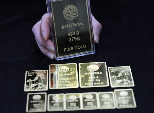서울 종로구 삼성금거래소에서 직원이 골드바를 들어보이고 있다. [연합뉴스]