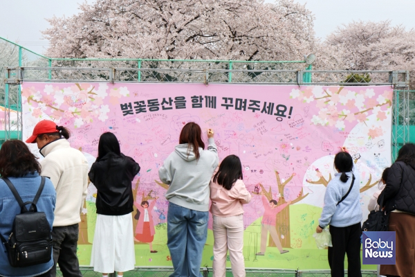 지난 11일 SK인천석유화학 벚꽃동산에 방문한 시민이 가족돌봄아동을 위한 후원금 조성을 위해 챌린지에 참여하고 있다. ⓒ초록우산