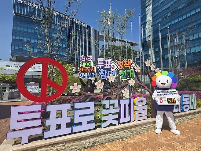 13일 대전시선거관리위원회 청사 앞에서 직원들이 제9회 전국동시지방선거 D-50을 알리는 퍼포먼스를 진행하고 있다. 대전선관위 제공
