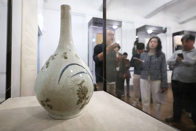 13일 서울 성북구 간송미술관에서 열린 2026 봄 특별 전시 '문화보국文化保國: 신념으로 지켜낸 우리의 얼' 기자간담회에서 참석자들이 '백자청화철채동채초충난국문병'을 살펴보고 있다. 전시는 일제강점기 우리 문화유산이 일본으로 팔려나가던 경성 고미술 경매장에서 간송 전형필이 되찾아온 미술품을 선보인다. 연합뉴스