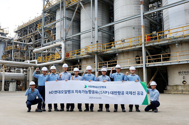 HD현대오일뱅크 관계자들이 지난해 9월22일 지속가능항공유(SAF)를 생산하는 수첨분해공정(MHC, Mild Hydrocracker) 앞에서 대한항공 국제선 SAF 공급 기념 촬영을 하고 있다. HD현대오일뱅크 제공