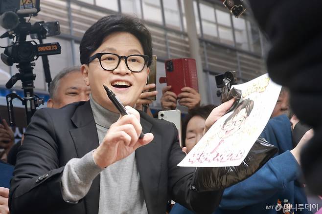 [서울=뉴시스] 정병혁 기자 = 한동훈 전 국민의힘 대표가 22일 서울 동대문구 경동시장을 찾아 시장상인에게 사인을 해주고 있다. (공동취재) 2026.03.22. photo@newsis.com /사진=