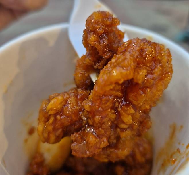 지난 12일 메가MGC커피 매장에서 주문한 ‘엠지씨네 양념 컵치킨’ 메뉴. 테이크아웃잔에 커피가 아닌 치킨과 떡 조각이 담겨 출출할 때도 충분히 뱃속을 달랠 수 있을 것으로 보인다. 김동환 기자