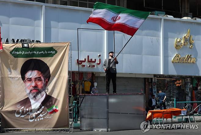 지난 10일 테헤란서 이란 최고지도자 대형 사진 옆에서 이란 국기 흔드는 시민 [EPA=연합뉴스 자료사진]