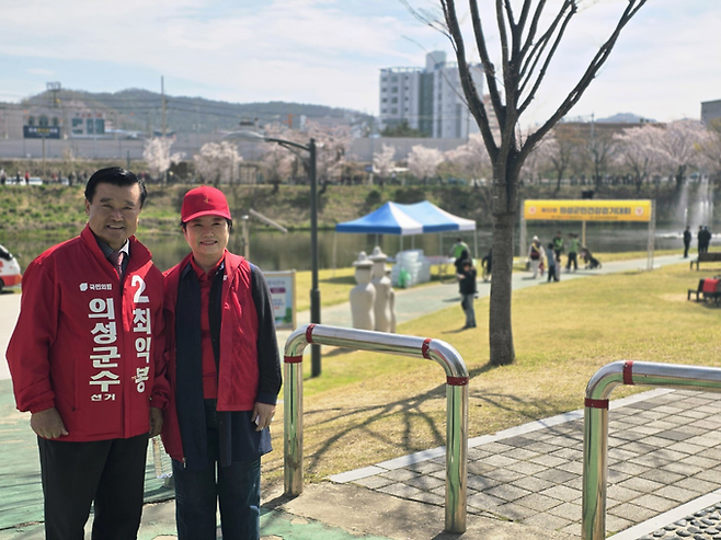 ▲ 최익봉 의성군수 예비후보와 배우자가 12일 의성군 구봉공원 문소루 아래 음악분수 광장에서 열린 제32회 의성군민건강걷기대회 현장을 찾아 기념촬영을 하고 있다. 최 예비후보 부부는 이날 행사장 일대에서 주민들과 인사를 나누며 현장 분위기를 살폈다. 김동현 기자 jhass80@kyongbuk.com