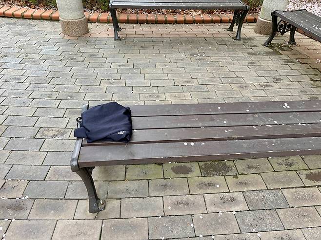 가지런히 접혀 놀이터 옆 벤치에 놓인 누군가의 옷가지. /정옥희 무용평론가