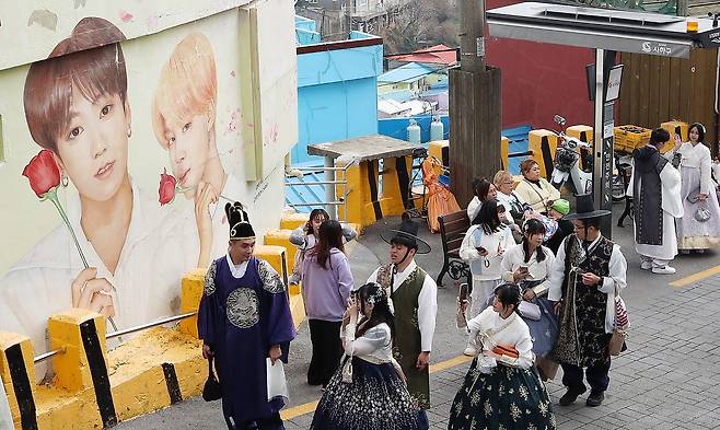 부산 서구 감천문화마을에서 외국인 관광객들이 부산이 고향인 BTS 멤버 정국·지민이 그려진 대형 벽화를 배경으로 기념촬영을 하고 있다. 뉴스1