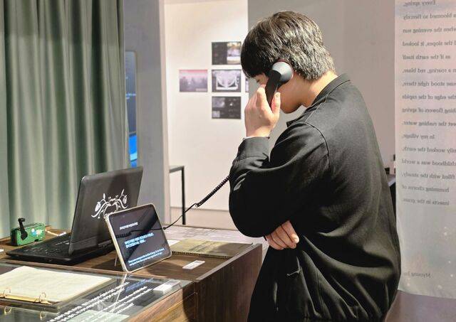 관람객이 수화기 모형을 들고 탈북민의 증언을 듣는 모습.