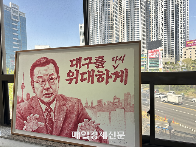 13일 방문한 김부겸 더불어민주당 대구시장 후보 캠프에 김 후보의 그림이 걸려 있다. 멀리 창밖으로 홍석준 국민의힘 예비후보의 현수막이 보인다. 김 후보 캠프에서는 평일 낮에도 적지 않은 유권자들이 오가는 모습을 볼 수 있었다. [대구=진영화 기자]