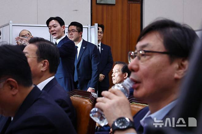 [서울=뉴시스] 김명년 기자 = 쌍방울 대북 송금 사건을 수사했던 박상용 검사가 14일 오전 서울 여의도 국회 '윤석열정권정치검찰조작기소의혹사건진상규명국정조사특별위원회'에서 열린 청문회에서 물 마시는 이화영 전 경기도 평화부지사 뒤로 선서 거부에 대한 육성 소명 기회를 요청하고 있다.  2026.04.14. kmn@newsis.com