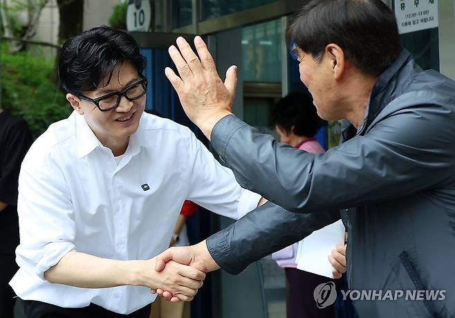 부산 북구 주민 된 한동훈 (부산=연합뉴스) 손형주 기자 = 한동훈 전 국민의힘 대표가 14일 오후 부산 북구 만덕2동 행정복지센터를 찾아 전입신고를 마친 뒤 주민과 인사하고 있다. 2026.4.14 handbrother@yna.co.kr