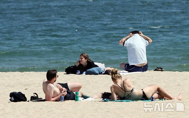 [부산=뉴시스] 하경민 기자 = 전국적으로 초여름 날씨를 보인 15일 부산 해운대구 해운대해수욕장을 찾은 외국인들이 일광욕을 즐기고 있다. 2026.04.15. yulnetphoto@newsis.com