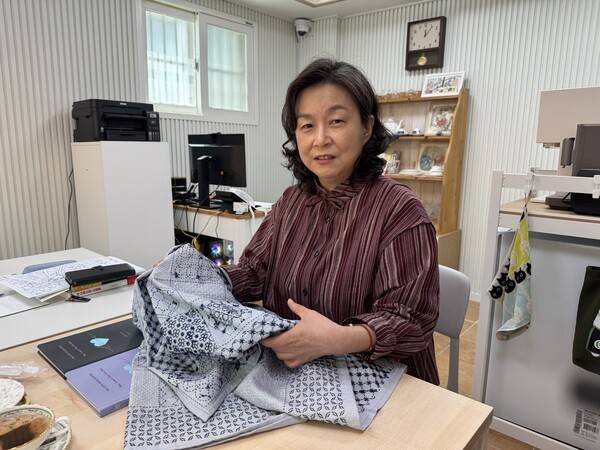 이홍은 대표가 일본 전통 자수 '사시코'의 패턴을 보여주며 설명하고 있다. 반복적인 패턴을 따라 바느질하는 과정은 손을 움직이며 집중과 안정감을 동시에 유도하는 인지 활동으로 활용된다. / 디멘시아뉴스