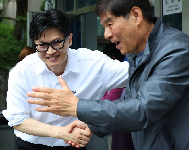 한동훈 전 국민의힘 대표가 14일 오후 부산 북구 만덕2동 행정복지센터를 찾아 전입신고를 마친 뒤 주민들과 사진을 찍고 있다. 한 전 대표는 이곳으로 전입신고를 하며 전재수 의원의 부산시장 출마로 보궐선거 진행될 예정인 부산 북구갑 출마를 공식화했다.(사진=연합뉴스)