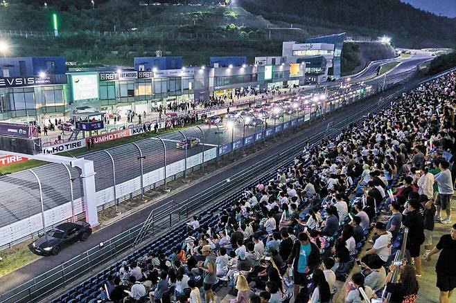 지난해 6월 강원도 인제군 인제스피디움에서 열린 ‘강원 국제 모터페스타’ 야간 레이스에서 관중석을 가득 메운 관람객들이 경주용 차량이 출발하는 장면을 지켜보고 있다. 이날만 서킷에 1만658명이 들어찼고, 지난해 인제스피디움 총 이용객은 18만8453명에 달했다. /인제군