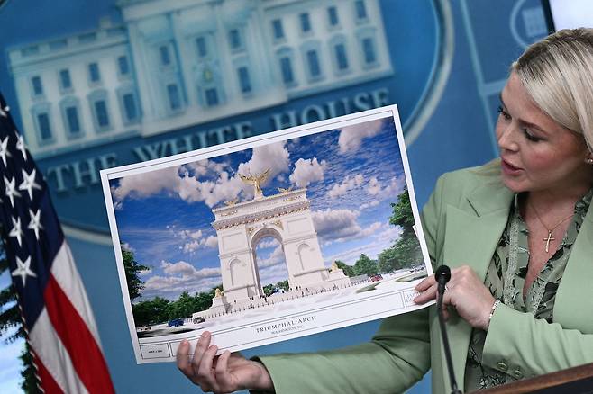 캐럴라인 레빗 미 백악관 대변인이 워싱턴DC 건설 예정인 초대형 개선문의 건축 계획 사진을 들고 있는 모습. /연합뉴스