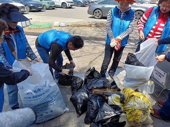 일산자생한방병원 관계자들과 일산자생봉사단원들이 고봉산에서 수거한 쓰레기를 정리하고 있다. ⓒ일산자생한방병원