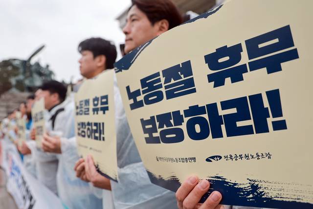 지난 3월 18일 국회 본청 앞 계단에서 전국공무원노동조합과 대한민국공무원노동조합총연맹이 연 공무원 노동절 휴무 쟁취 기자회견에서 참석자들이 손팻말을 들고 있다. 연합뉴스