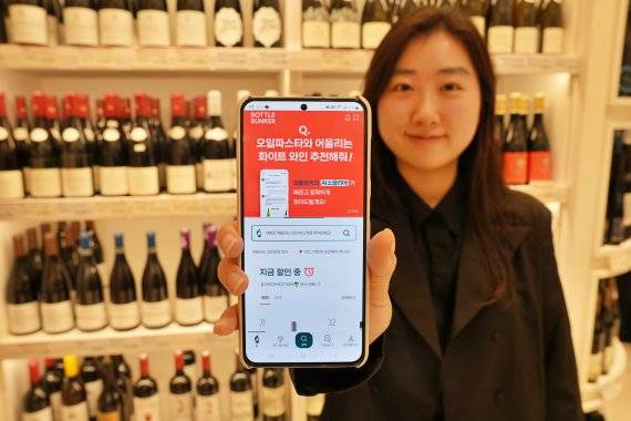 서울시 중구에 위치한 보틀벙커 서울역점에서 모델이 'AI 소믈리에' 서비스를 소개하고 있다. 롯데마트 제공