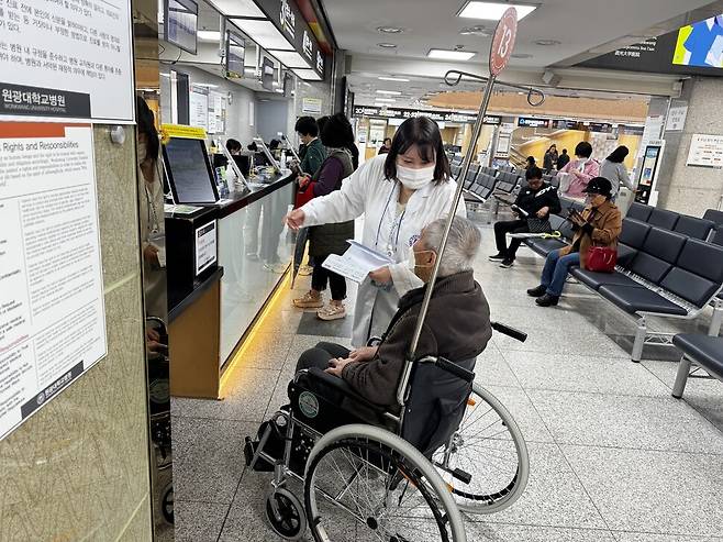 원광대병원 장애인 이용편의 지원 사업팀 지체장애인 휠체어 보조 동행 모습. 원광대병원 장애인 이용편의 지원 사업팀 제공