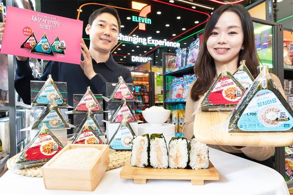 편의점 세븐일레븐에서 모델들이 라이스 프로젝트를 구현한 '올 뉴 삼각김밥'을 홍보하고 있다. [사진=세븐일레븐]