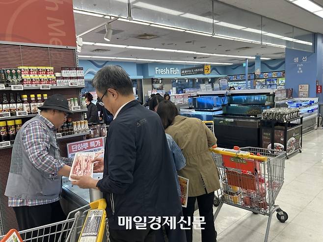 물품을 카드에 담는 손님들. [변덕호 기자]