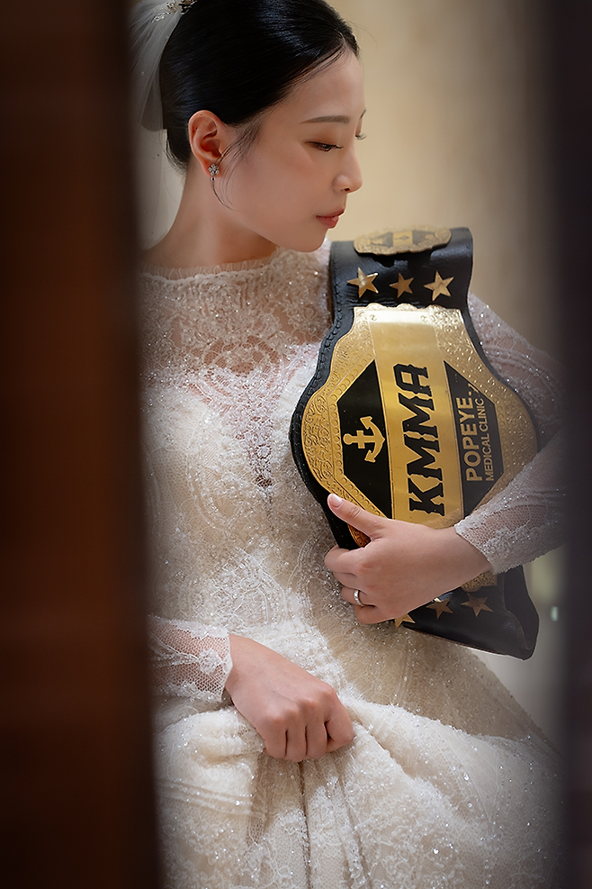 제2대 로드FC 여자 아톰급 챔피언 심유리가 2026년 4월 결혼식 입장을 기다리고 있다. 종합격투기 빅리그 일본 라이진 진출과 함께 로드FC 타이틀을 반납했기에 KMMA 챔피언 벨트를 빌렸다. 사진=뽀빠이연합의원KMMA파이터에이전시 제공