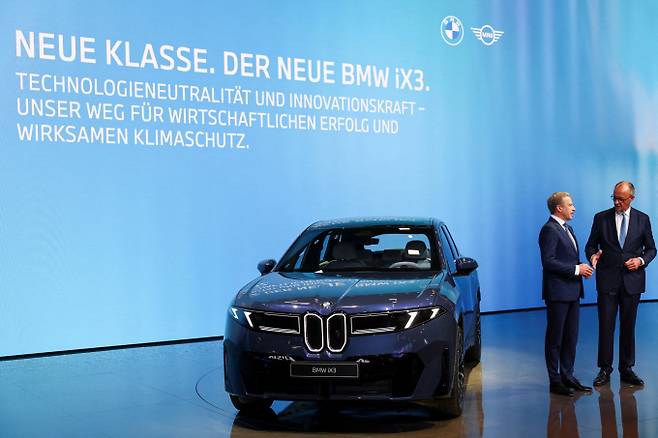 올리버 집세 BMW 그룹 최고경영자(CEO)가 2025년 9월9일 독일 뮌헨에서 열린 IAA Mobility 2025 행사장에서 BMW iX3 옆에서 프리드리히 메르츠 독일 총리와 대화를 나누고 있다. /로이터=뉴스1