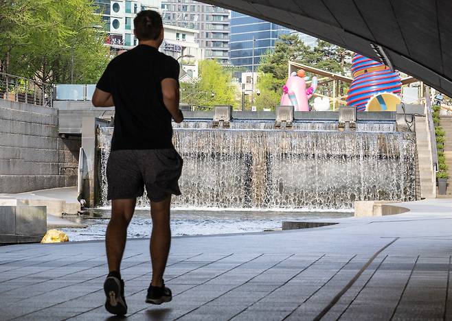 3월 평균기온이 9년 연속 평년보다 높은 기온을 기록하며 뚜렷한 온난화 추세를 보이고 있다. 사진은 한낮 기온이 27도까지 오른 14일 서울 청계천에서 한 시민이 가벼운 옷차림으로 운동하는 모습.  윤창빈 기자