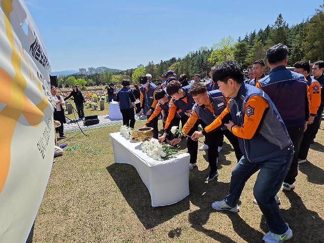 소방대원들이 세월호 참사 헬기 수색 지원을 마치고 복귀하다, 헬기 추락으로 순직한 소방관 5명에게 헌화하고 있다. 박우경 기자