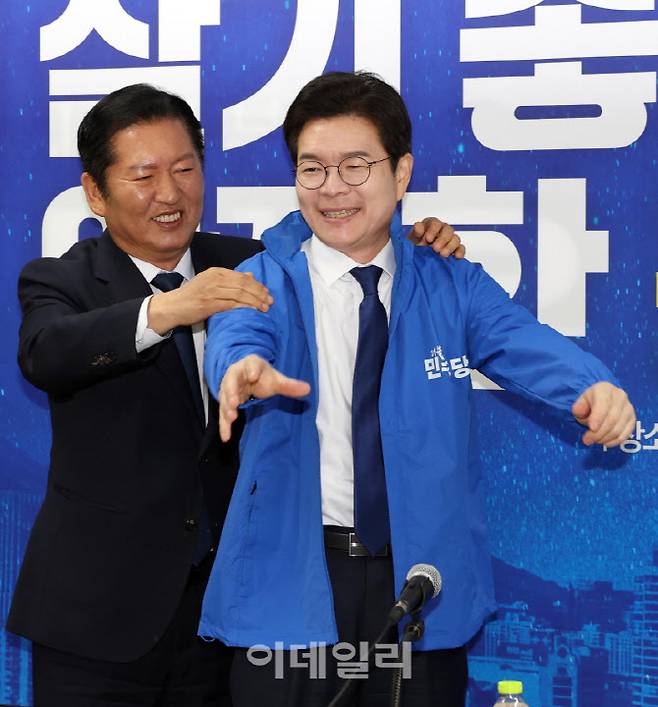 정청래 더불어민주당 대표가 17일 서울 용산 강태웅 용산구청장 후보 사무소에서 정원오 서울시장 후보에 당 점퍼를 입히고 있다. (사진=노진환 기자)