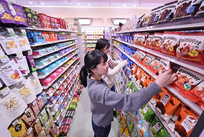 서울 성동구에 오픈한 디저트 특화 편의점 'CU 성수디저트파크점'에서 관계자가 진열된 상품을 살펴보고 있다. /연합뉴스